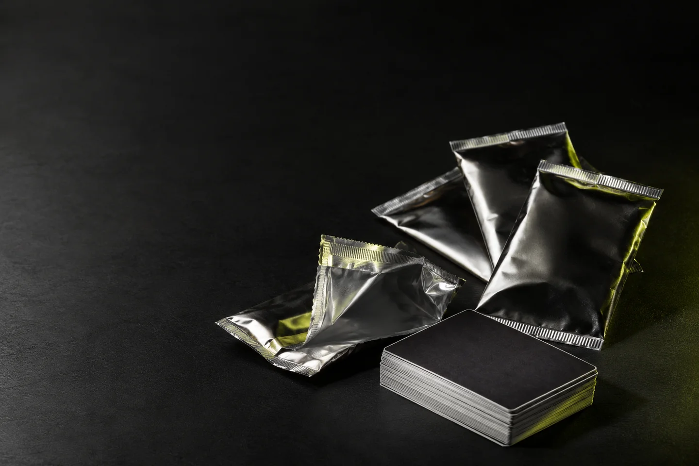 Illustrative silver and black trading-card packs beside a stack of face-down cards